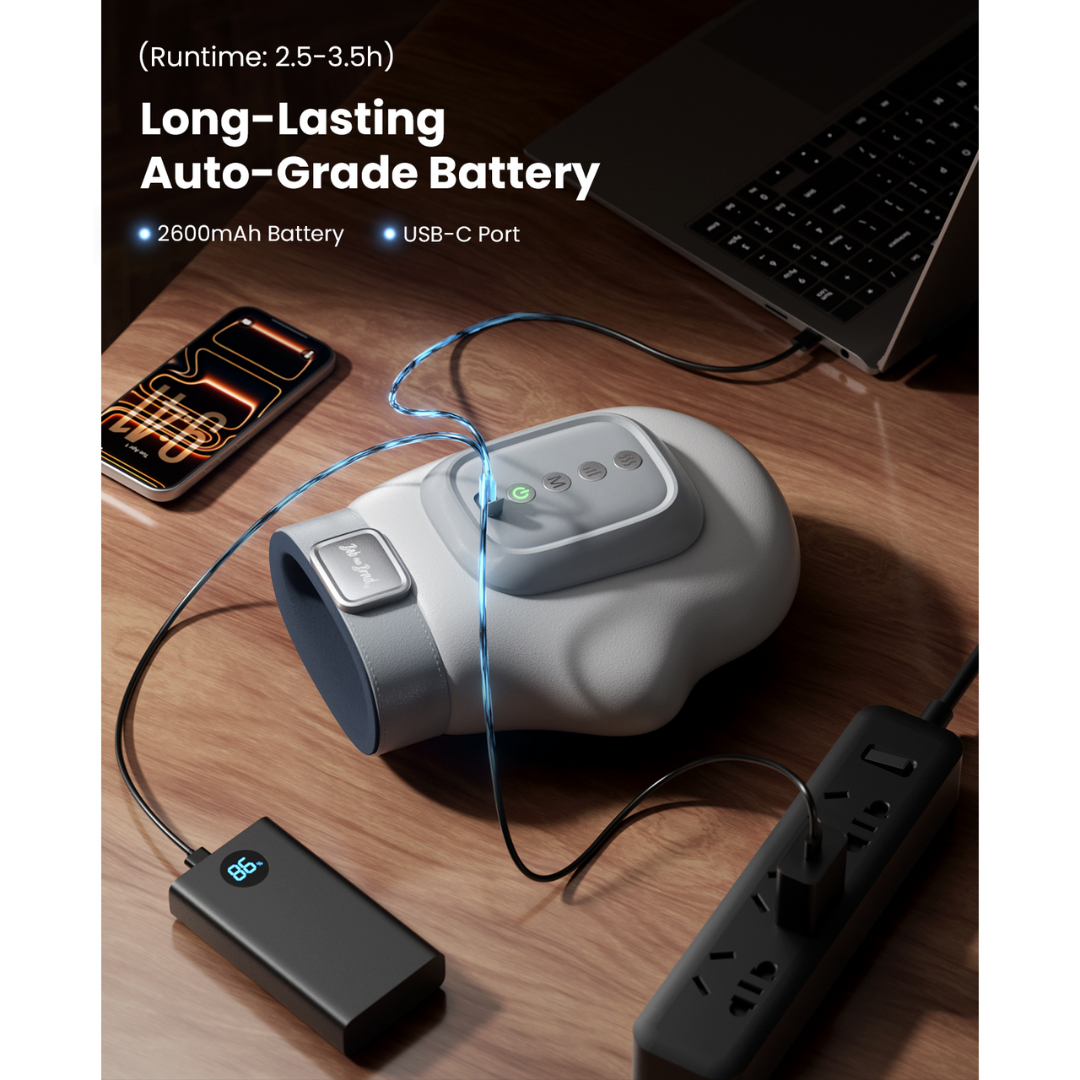 Hand massager, laptop, smartphone, and power strip on a wooden surface with text about long-lasting auto-grade battery. Text includes: (runtime: 2.5 - 3.5h), 2600Ah battery, USB-C port.