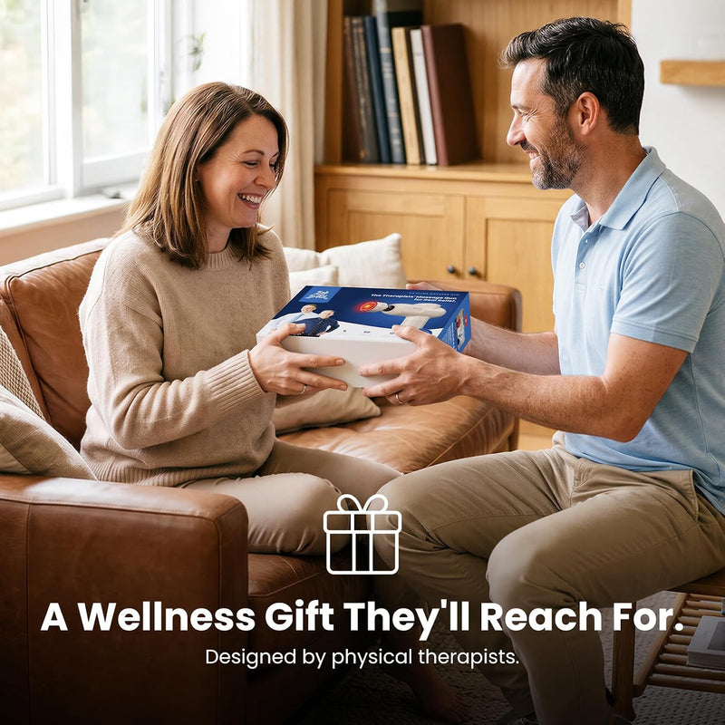 Man giving a woman the Bob and Brad C2 Ultra Massage Gun as a gift while sitting on a couch. Text reads, “A Wellness Gift They’ll Reach For. Designed by physical therapists.”
