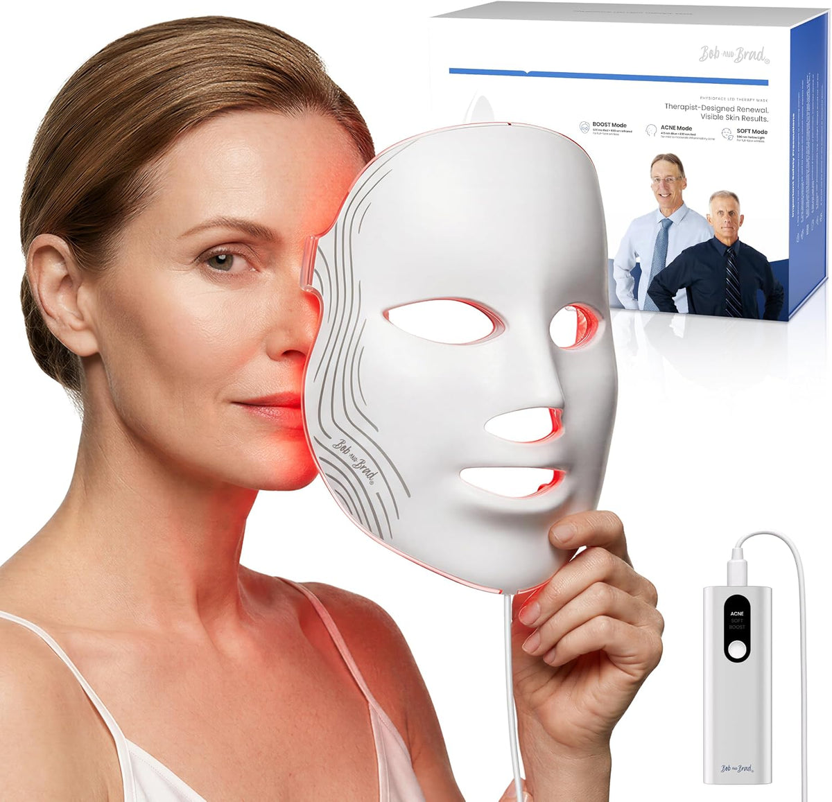 A woman holds a white LED facial therapy mask against her face, with red light glowing from the mask. The image also shows the product's power adapter and its retail box in the background.