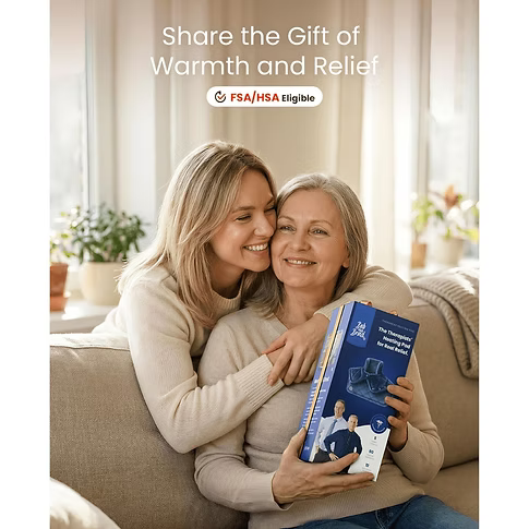 A woman and an older woman hug on a beige sofa in a bright living room, with the younger woman holding a blue heating pad box. Text at the top reads 'Share the Gift of Warmth and Relief' with an FSA/HSA eligible badge.