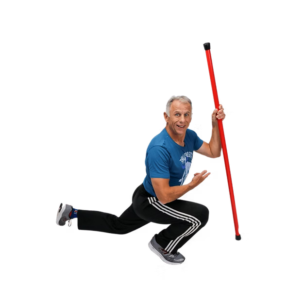 Brad is in a blue shirt and black pants, standing in a lunge position and holding a red Booyah Stik on a white background