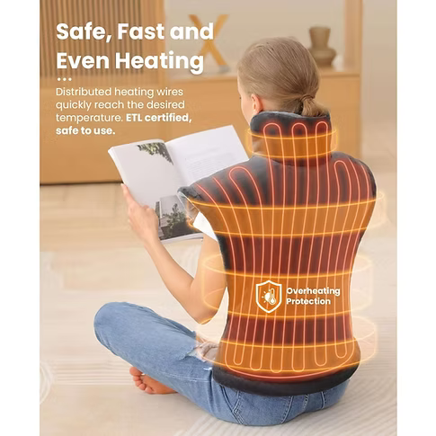 A woman sits cross-legged on a light floor reading a book in a warm indoor room, wearing a grey neck and upper back heating pad with glowing orange heat lines overlaid on the product area. Text on the image reads 'Safe, Fast and Even Heating' and 'Distributed heating wires quickly reach the desired temperature. ETL certified, safe to use.