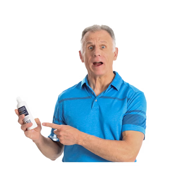 Brad, in a bright blue polo shirt pointing to and holding a small white bottle of the Holy Cowabunga cream with a dark blue label on a plain white background.