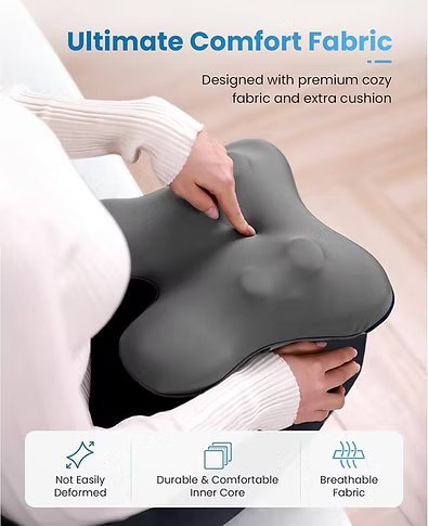 A dark gray contoured back massager pillow is being held by a person wearing a white ribbed sweater. The image features marketing text at the top reading 'Ultimate Comfort Fabric' and three feature icons at the bottom describing 'Not Easily Deformed', 'Durable & Comfortable Inner Core', and 'Breathable Fabric'.